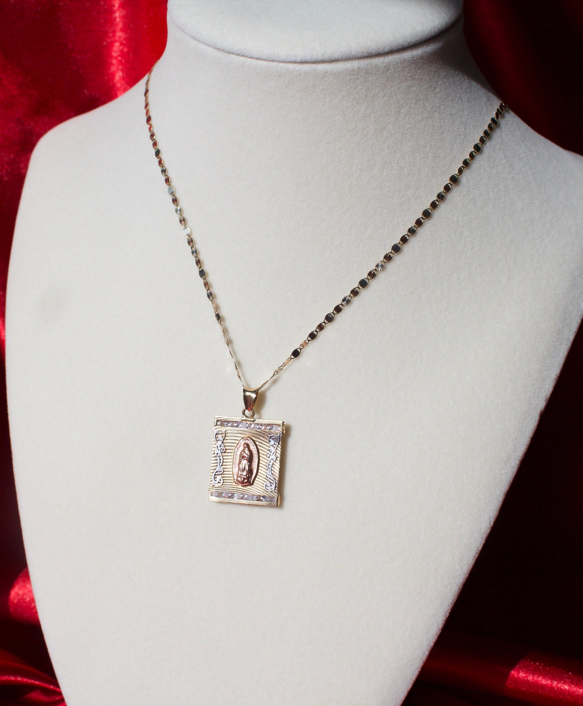 Jewelry necklace with pendant on a mannequin against a red satin background